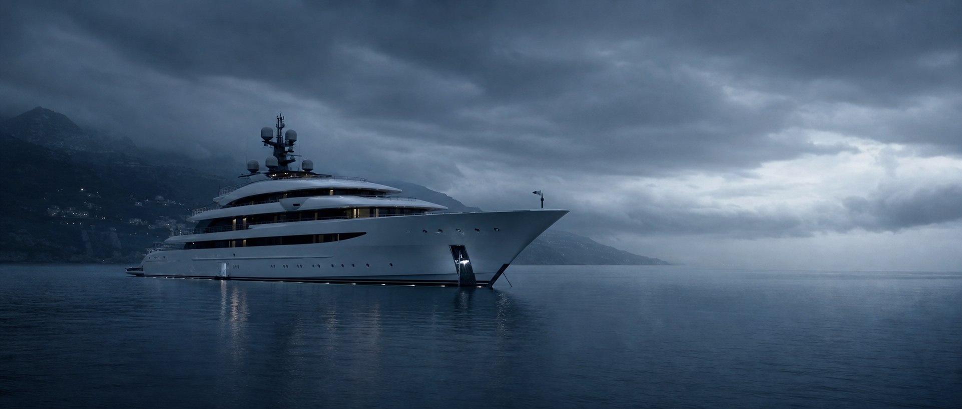 White megayacht anchored in open water at blue dusk