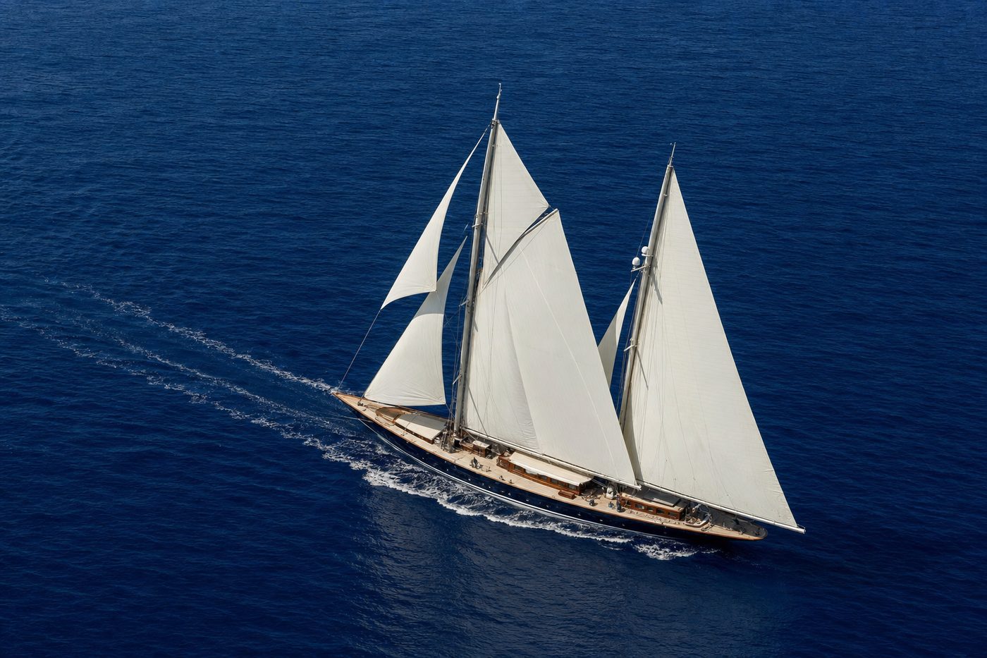 Twin-mast sailing superyacht under full sail, aerial view